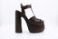 La sandale CASADEI Florence Sella en cuir brun offre un talon de 15 cm avec une plateforme de 5 cm et une boucle dorée. Le cuir tressé à l'avant-pied ajoute une touche élégante à cette sandale. Profitez du confort du talon et de la plateforme en bois pour une démarche assurée.